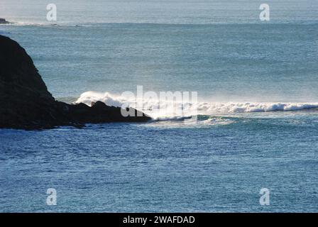 Panorama depuis le haut de la côte au-dessus de la plage de Sopelana près de Bilbao, Espagne. Détail des vagues qui s'écrasent sur les rochers générant de la mousse blanche. Banque D'Images