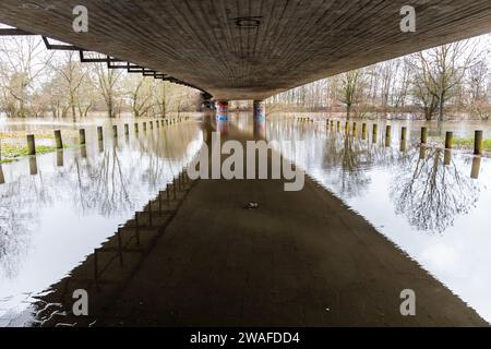 04 janvier 2024, Hesse, Gießen : le Lahn a fait éclater ses banques. Le sentier pédestre et la piste cyclable (au premier plan) sous le pont Konrad Adenauer sont déjà inondés. Photo : Christian Lademann/dpa Banque D'Images