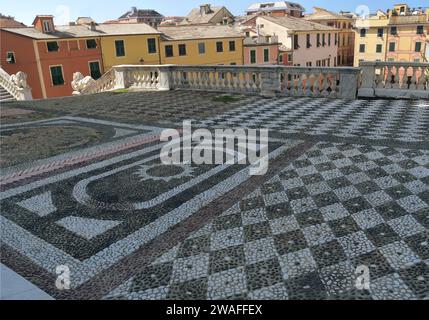 La Basilique de Santo Stefano à Lavagna est un chef-d'œuvre de marbre, balustrades, escaliers, cimetières et lions parmi les maisons sombres colorées Banque D'Images