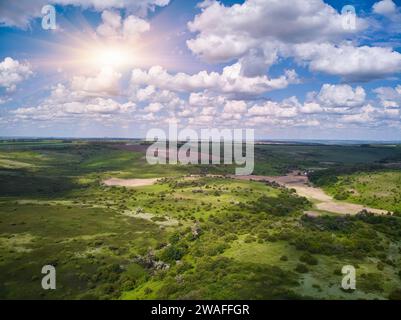 Splendide photographie aérienne de champs ondulés verts par temps ensoleillé. Vue de dessus tir de drone. Zone agricole de l'Ukraine, Europe. Concept de l'industrie agraire. Banque D'Images