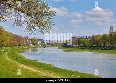 rive de la rivière uzh. magnifique paysage urbain en été. vue de dessous l'ombre d'un arbre de linden branches. pont au loin Banque D'Images