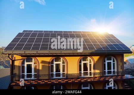 Panneaux solaires sur petit panneau de bois maison intérieure toit, concept d'énergie durable. Beaucoup d'espace de copie sur ciel bleu clair. Banque D'Images