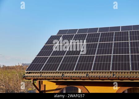 Panneaux solaires sur petit panneau de bois maison intérieure toit, concept d'énergie durable. Beaucoup d'espace de copie sur ciel bleu clair. Banque D'Images