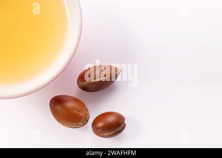 Concept de perte de cheveux. Graines d'argan et huile isolées sur fond blanc Banque D'Images