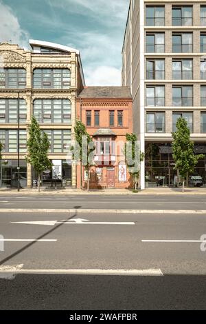 Un bâtiment historique en briques rouges à la périphérie du centre-ville de Manchester. Maintenant classé Grade II et pris en sandwich entre deux blocs d'appartements. Banque D'Images