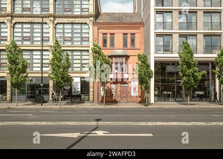 Un bâtiment historique en briques rouges à la périphérie du centre-ville de Manchester. Maintenant classé Grade II et pris en sandwich entre deux blocs d'appartements. Banque D'Images