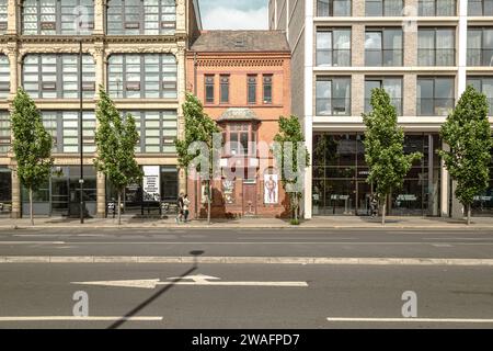 Un bâtiment historique en briques rouges à la périphérie du centre-ville de Manchester. Maintenant classé Grade II et pris en sandwich entre deux blocs d'appartements. Banque D'Images