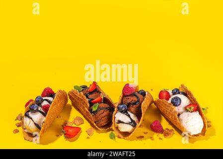 Diverses crèmes glacées au taco sucré. Coquilles de tacos à gaufrer avec glace au chocolat et à la vanille avec différents fruits, baies, garnitures Banque D'Images