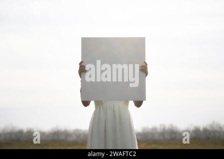 femme surréaliste avec une toile vierge devant son visage ; concept abstrait Banque D'Images