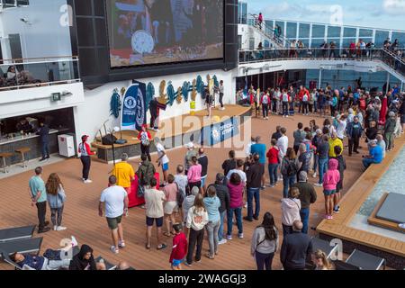 Vue générale des passagers profitant d'un événement maritime sur le pont de la piscine sur le MSC Euribia naviguant en Europe du Nord (juillet 23). Banque D'Images