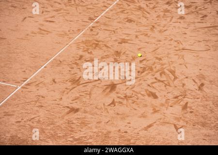 Balle de tennis isolée sur la surface d'argile du court de tennis Banque D'Images