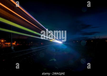 Lignes lumineuses de train de couleur dans la nuit sombre dans le sud de la Bohême près de la gare de Protivin Banque D'Images