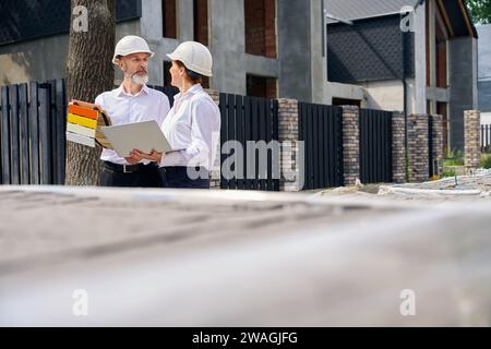 Client choisissant la couleur de peinture de façade assisté par un professionnel Banque D'Images