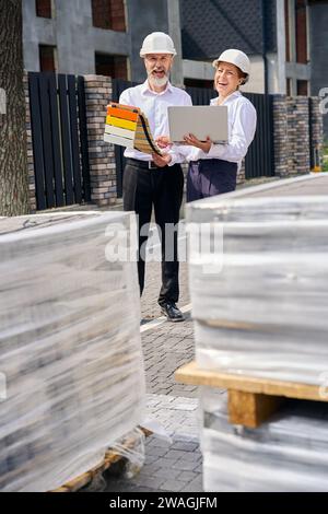 Expert en construction aidant le client dans le choix de la couleur de peinture extérieure Banque D'Images