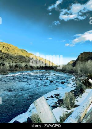 Voir la vue sur la rivière Shoshone après la première tempête de neige. De la neige a déjà fondu et le soleil projette de lourdes ombres. Le jaune vif contraste avec les bleus profonds. Banque D'Images