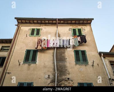 Séchage du linge à la façade d'une ancienne maison résidentielle en Toscane, Italie Banque D'Images