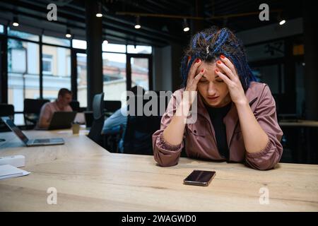 Contrarié femme frustrée regardant le smartphone, attendant un appel important Banque D'Images