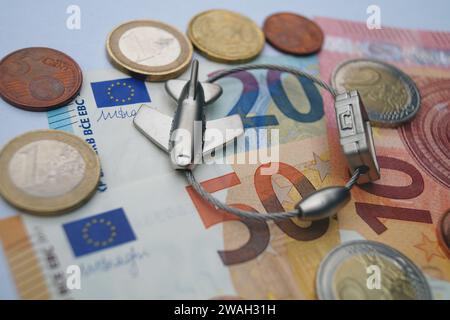 Serrure à bagages en forme d'avion et d'argent, symbole image des frais de voyage Banque D'Images