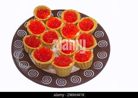 Tartelettes au caviar rouge et au beurre sur une assiette isoler sur fond blanc. Banque D'Images