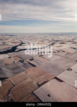 Vue de surface des terres agricoles s'étendant au loin sous un ciel d'hiver brumeux Banque D'Images