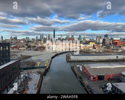 En regardant vers le bas du canal Gowanus, un site pollué de superfund, avec l'horizon toujours croissant du centre-ville de Brooklyn au loin. Banque D'Images