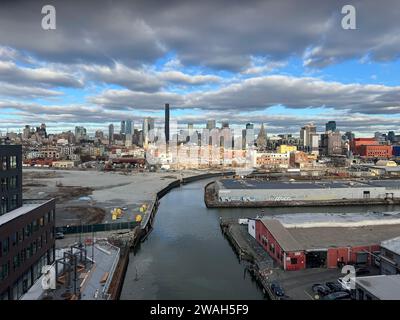 En regardant vers le bas du canal Gowanus, un site pollué de superfund, avec l'horizon toujours croissant du centre-ville de Brooklyn au loin. Banque D'Images