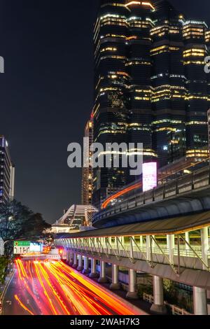 Passage du train de métro bts sur un pont supérieur parmi les gratte-ciel au pont piétonnier de Chong Nonsi à Bangkok, Thaïlande 27 décembre 2023. Banque D'Images