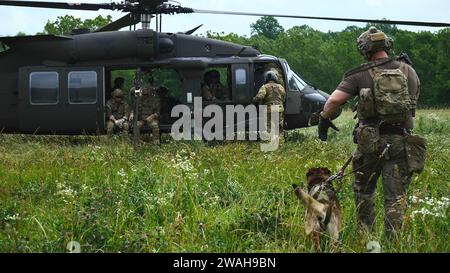 Des Rangers du 2e bataillon, du 75e régiment de Rangers, et des membres de la section K9, du 75e régiment de Rangers, se préparent à embarquer à bord d'un UH-60M Blackhawk au Muscatatuck Urban Training Center près de Butlerville, Indiana, le 20 juin 2023. Les Rangers et l'équipe K9 ont mené un exercice de formation rapide sur le système d'insertion et d'extraction de corde avec les équipages de conduite du 1e Bataillon, 137e Régiment d'aviation, 73e Commandement de troupe. L'événement conjoint a permis à la fois la validation et la familiarisation avec les techniques DE FRITES pour l'équipage de conduite, les Rangers et la section K9. (Photo de la Garde nationale de l'armée américaine par l'état-major. Sergent Aven Santiago, 196e. Banque D'Images