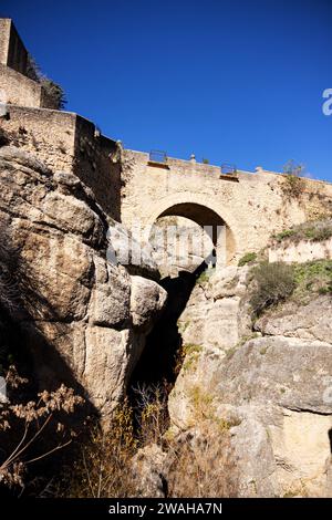 En regardant le vieux pont du XVIe siècle (Puente Viejo) sur la rivière Guadalevin dans la gorge qui traverse Ronda, Málaga, Espagne. Banque D'Images