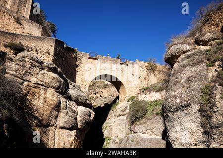 En regardant le vieux pont du XVIe siècle (Puente Viejo) sur la rivière Guadalevin dans la gorge qui traverse Ronda, Málaga, Espagne. Banque D'Images