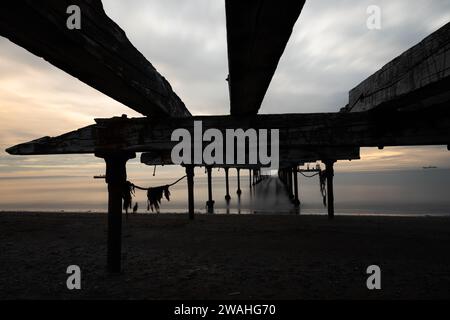 photo longue exposition sous une jetée abandonnée au coucher du soleil Banque D'Images