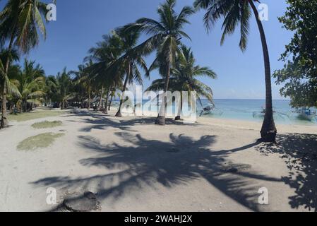 Un bateau traditionnel philippin ou Outrigger est amarré à l'île de Kalanggaman par une belle journée claire et ancré sur une plage de sable. Banque D'Images