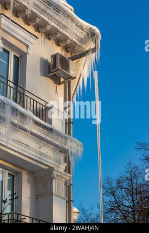 Vue verticale d'une maison de ville résidentielle couverte de glaçons et de glace en hiver Banque D'Images