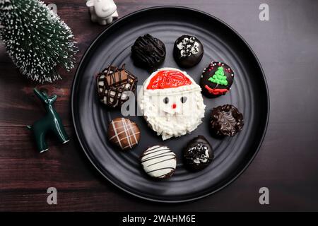 Beignets de Noël glacés faits maison. Les beignets de Noël assortis incluent renne, Père Noël, arbre de Noël et chocolat. fond du festival. Banque D'Images