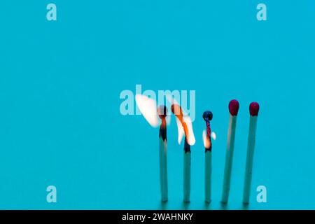 Flammes de trois sur cinq pointes rouges allumettes brûlant sur un fond bleu Banque D'Images