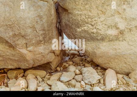 Gros plan de deux gros rochers reposant l'un contre l'autre formant un petit triangle avec des rochers plus petits au premier plan Banque D'Images