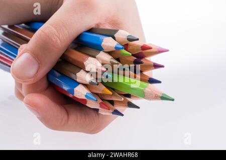 Main tenant crayons de couleur sur un fond blanc Banque D'Images