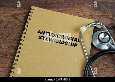 Concept d'intendance antimicrobienne écrire sur le livre avec stéthoscope isolé sur la table en bois. Banque D'Images