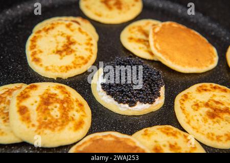 Blinis au caviar noir et fromage à la crème, sur un plat festif, mini crêpes, un élégant apéritif Banque D'Images