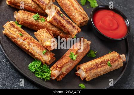 pain grillé français au jambon et au fromage au blé entier servi avec sauce tomate sur une assiette noire sur une table en béton gris, gros plan Banque D'Images