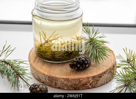 Fabrication de sirop d'aiguilles de pin frais. Bocaux en verre avec des aiguilles infusées avec de l'eau dans la cuisine à la maison. Banque D'Images