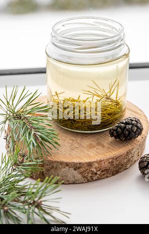 Fabrication de sirop d'aiguilles de pin frais. Bocaux en verre avec des aiguilles infusées avec de l'eau dans la cuisine à la maison. Banque D'Images