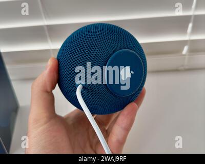 Un gros plan d'un Homepod Mini Apple bleu sur un rebord de fenêtre blanc Banque D'Images