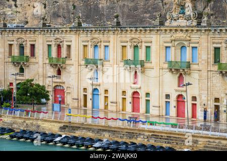 Grand Harbour Valletta Malte août 31 2023 maisons d'architecture front de mer et avec rangée de Jet Sky dans le port et bandoulière colorée sur le guardr Banque D'Images