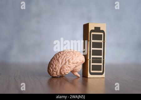 Image en gros plan du cerveau et des blocs de bois avec l'icône de batterie pleine énergie. Puissance mentale, concept d'énergie mentale. Banque D'Images