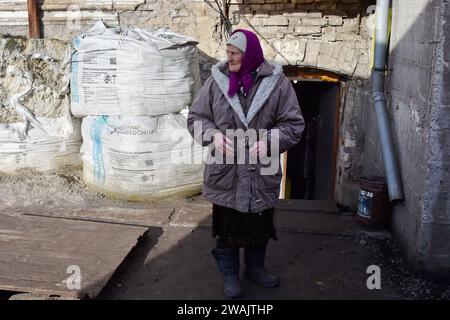 Orikhiv, Ukraine. 04 janvier 2024. Une femme âgée se tient à l'entrée de son refuge à Orikhiv. À quelques kilomètres de la ligne de front sud-est, Orikhiv est devenue une ville fantôme près de deux ans après que la Russie ait lancé une invasion à grande échelle de l’Ukraine. Des maisons ont été détruites, des bâtiments réduits en décombres et des magasins fermés en raison des bombardements quotidiens russes et des frappes aériennes. Avant la guerre, Orikhiv abritait plus de 14 000 000 personnes. Près de deux ans plus tard, il a été largement réduit en décombres. Crédit : SOPA Images Limited/Alamy Live News Banque D'Images