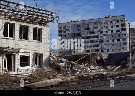 Orikhiv, Ukraine. 04 janvier 2024. Vue d'un immeuble d'appartements et d'un marché qui ont été endommagés par les bombardements russes à Orikhiv. À quelques kilomètres de la ligne de front sud-est, Orikhiv est devenue une ville fantôme près de deux ans après que la Russie ait lancé une invasion à grande échelle de l’Ukraine. Des maisons ont été détruites, des bâtiments réduits en décombres et des magasins fermés en raison des bombardements quotidiens russes et des frappes aériennes. Avant la guerre, Orikhiv abritait plus de 14 000 000 personnes. Près de deux ans plus tard, il a été largement réduit en décombres. Crédit : SOPA Images Limited/Alamy Live News Banque D'Images