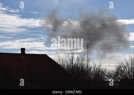 Orikhiv, Ukraine. 04 janvier 2024. La fumée monte sur les toits des maisons privées après les frappes aériennes russes à Orikhiv. À quelques kilomètres de la ligne de front sud-est, Orikhiv est devenue une ville fantôme près de deux ans après que la Russie ait lancé une invasion à grande échelle de l’Ukraine. Des maisons ont été détruites, des bâtiments réduits en décombres et des magasins fermés en raison des bombardements quotidiens russes et des frappes aériennes. Avant la guerre, Orikhiv abritait plus de 14 000 000 personnes. Près de deux ans plus tard, il a été largement réduit en décombres. Crédit : SOPA Images Limited/Alamy Live News Banque D'Images