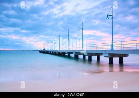 La jetée de Val Street sur l'estran de Rockingham avec un coucher de soleil coloré dans la banlieue côtière sud de Rockingham, Perth, Australie occidentale. Banque D'Images