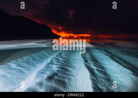 Vue partagée avec coucher ou lever du soleil et fond de mer sablonneux sous-marin. Mer tropicale avec coucher de soleil ou lever de soleil lumineux coloré, vue sous-marine avec flash lig Banque D'Images